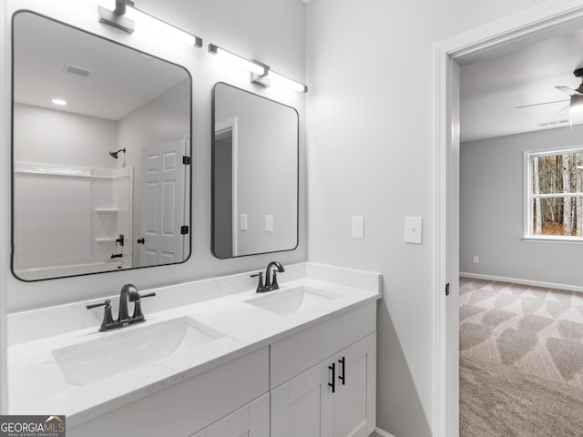 bathroom featuring double vanity, a sink, a ceiling fan, and baseboards