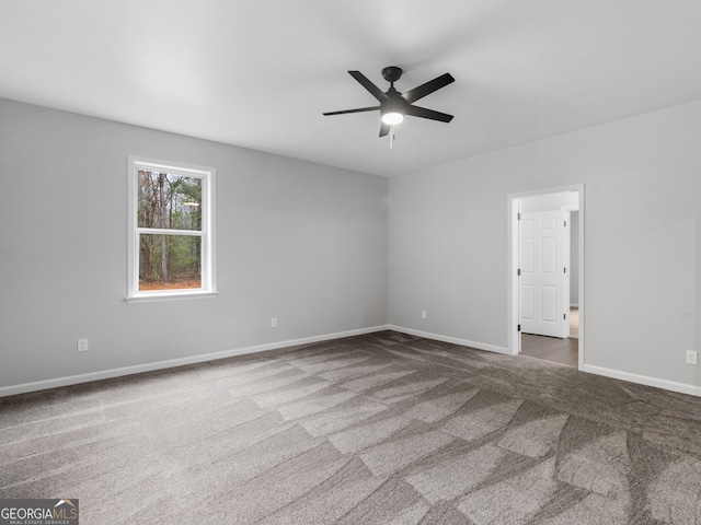 spare room featuring carpet, ceiling fan, and baseboards