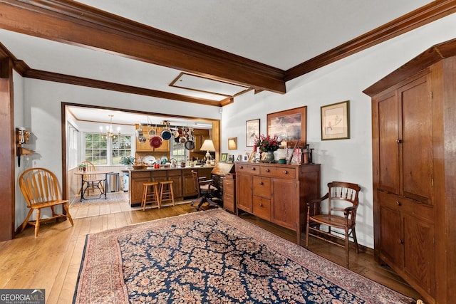 interior space featuring beam ceiling, a notable chandelier, ornamental molding, light wood-type flooring, and baseboards