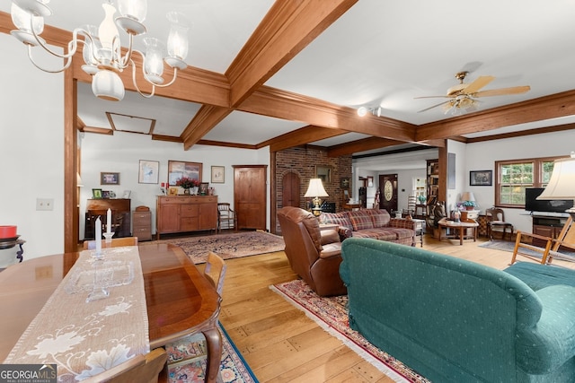 living room featuring beam ceiling, hardwood / wood-style flooring, ornamental molding, coffered ceiling, and ceiling fan with notable chandelier