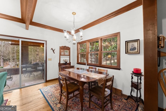 dining area with ornamental molding, wood-type flooring, visible vents, and baseboards