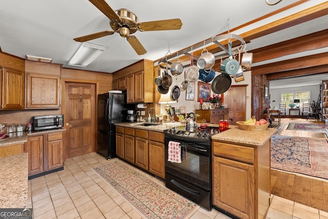 kitchen with black appliances, brown cabinetry, a sink, and light tile patterned flooring