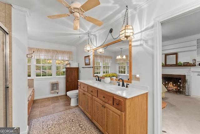 bathroom featuring heating unit, a wealth of natural light, and a sink