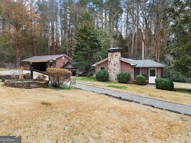 view of property exterior with brick siding, a lawn, and a chimney