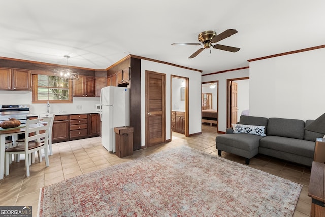 kitchen with light tile patterned floors, open floor plan, light countertops, freestanding refrigerator, and crown molding