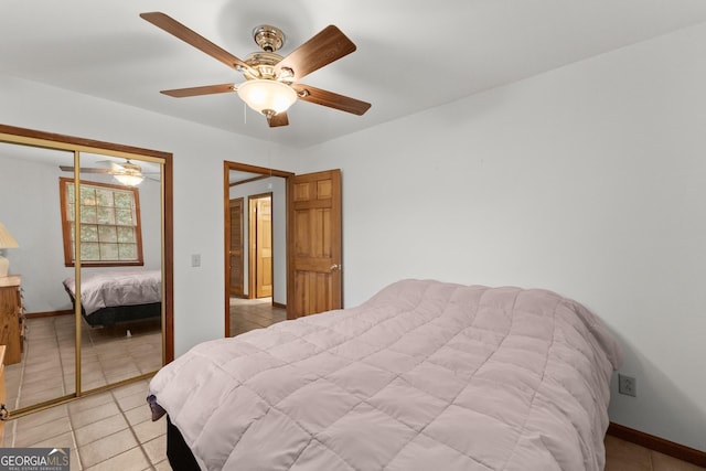 bedroom with light tile patterned floors, ceiling fan, baseboards, and a closet