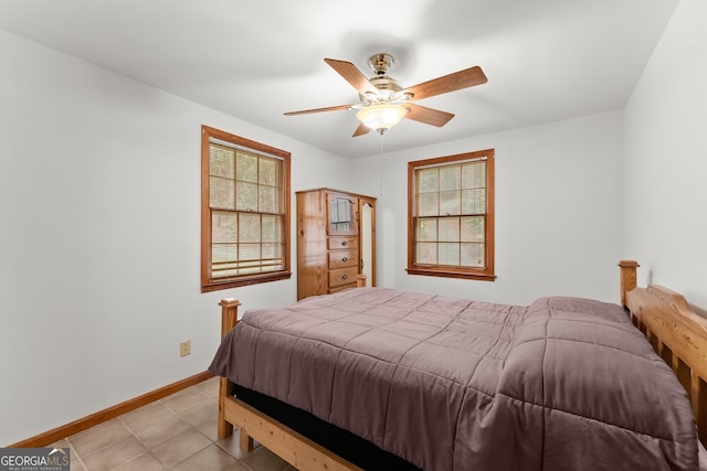 bedroom with a ceiling fan, baseboards, and light tile patterned floors