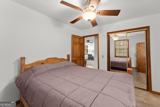 bedroom with light tile patterned floors, ceiling fan, baseboards, and a closet