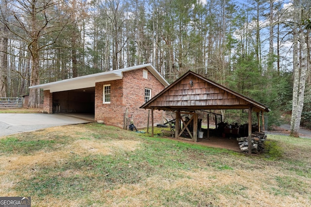 view of front of property with a front lawn, an attached carport, concrete driveway, and brick siding