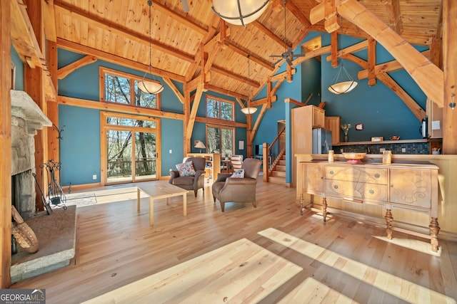 living area featuring a fireplace, wood ceiling, stairs, beamed ceiling, and wood-type flooring