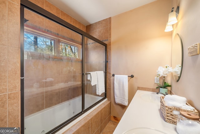 full bathroom featuring double vanity, tiled shower / bath, and a sink