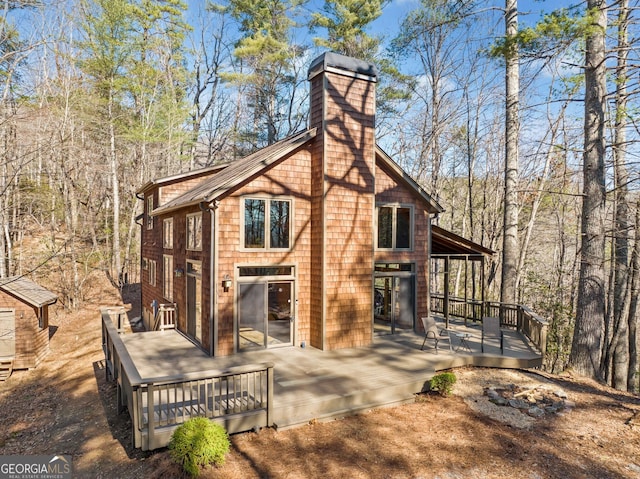 view of property exterior with a chimney and a wooden deck