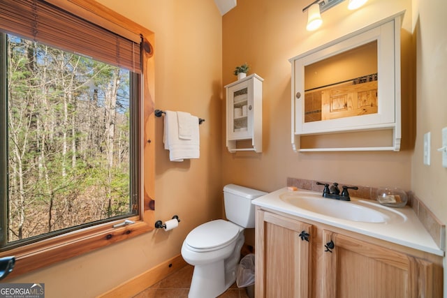 bathroom with a wealth of natural light, vanity, toilet, and tile patterned floors