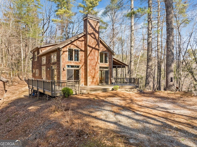 exterior space featuring a chimney and a wooden deck