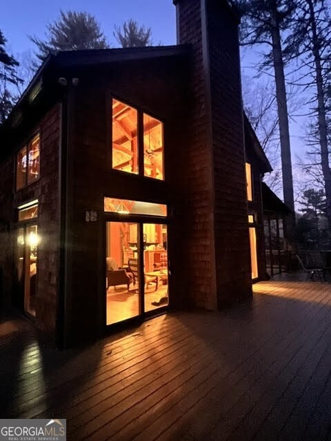 rear view of house with a chimney and a wooden deck