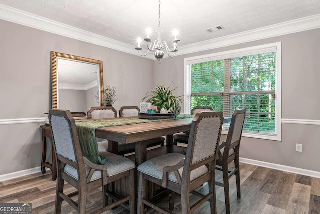 dining space featuring ornamental molding, dark wood-style flooring, visible vents, and an inviting chandelier