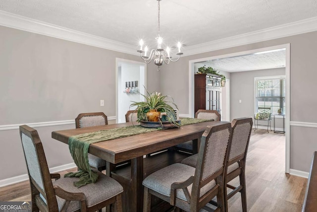 dining area with an inviting chandelier, wood finished floors, and baseboards