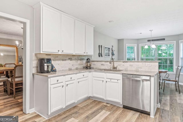 kitchen with dishwasher, a peninsula, a sink, and white cabinetry