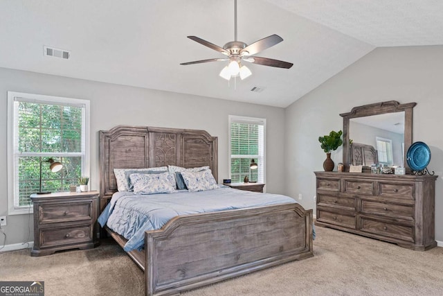 bedroom with lofted ceiling, light carpet, and visible vents