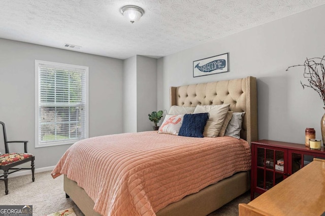 carpeted bedroom with baseboards, visible vents, and a textured ceiling