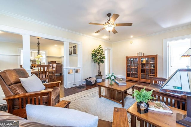 living room featuring dark wood-style floors, decorative columns, ornamental molding, and ceiling fan