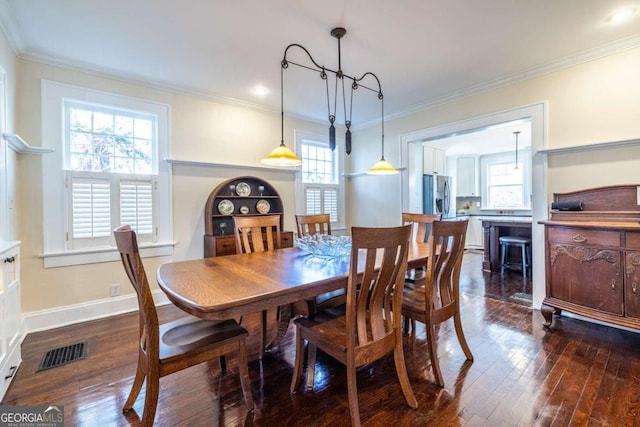 dining room with ornamental molding, visible vents, dark wood finished floors, and baseboards