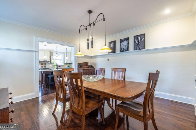 dining room with dark wood-style floors, crown molding, and baseboards