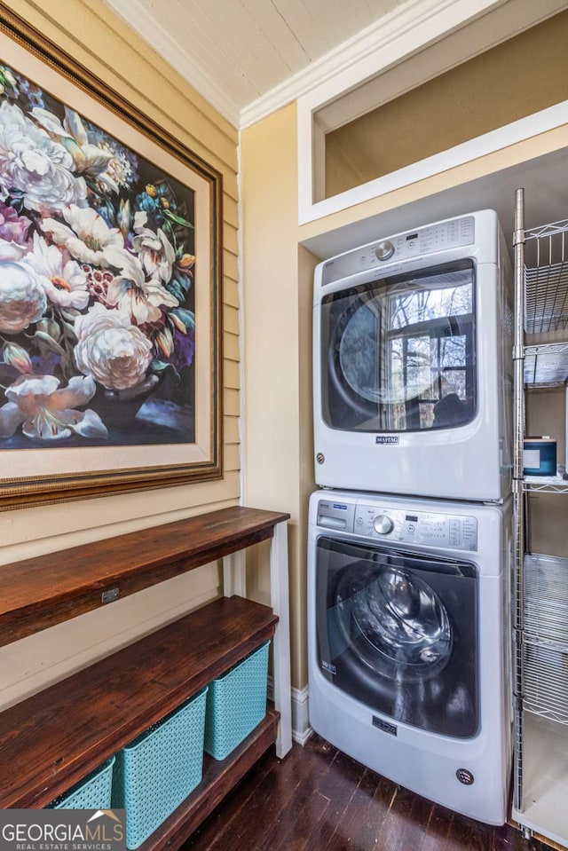 laundry room with crown molding, laundry area, dark wood-style flooring, and stacked washer / drying machine