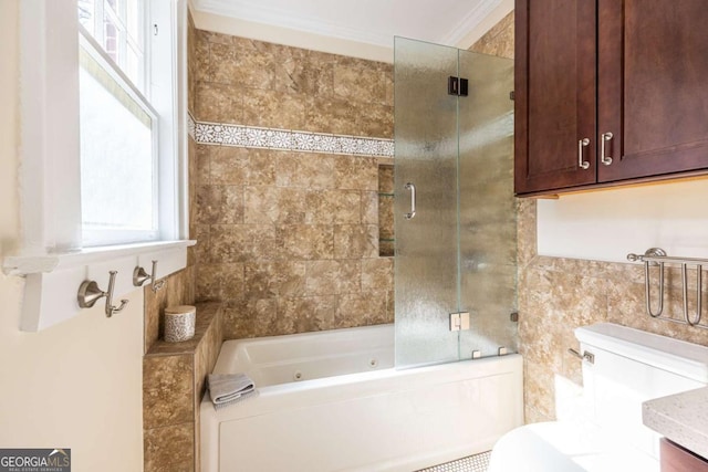 bathroom featuring toilet, shower / bath combination with glass door, crown molding, vanity, and tile walls