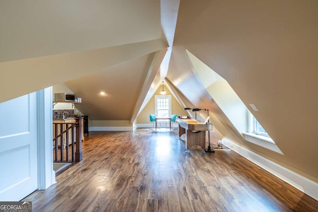 additional living space with lofted ceiling, baseboards, and wood finished floors