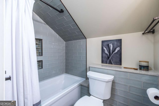 bathroom with toilet, vaulted ceiling, and shower / tub combo with curtain