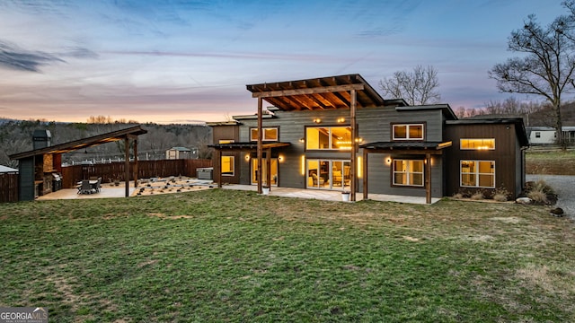 rear view of property with a patio area, a yard, metal roof, and a standing seam roof