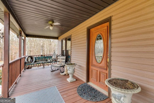 entrance to property with ceiling fan and a porch