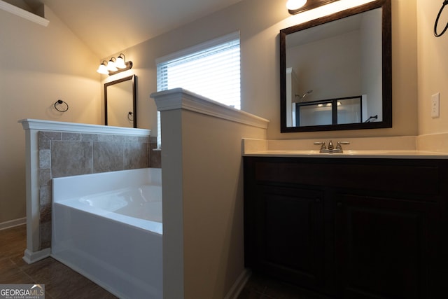 full bathroom with baseboards, tile patterned floors, a garden tub, vaulted ceiling, and vanity