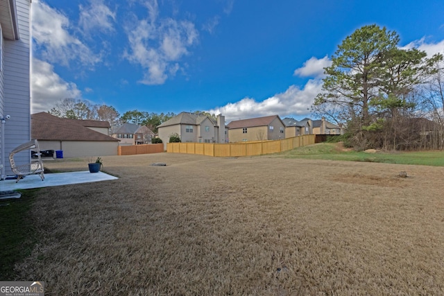 view of yard with a fenced backyard, a residential view, and a patio