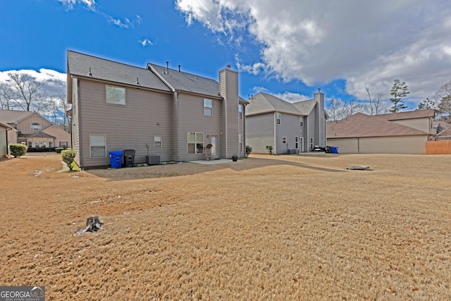 back of house with a residential view, a lawn, and central air condition unit