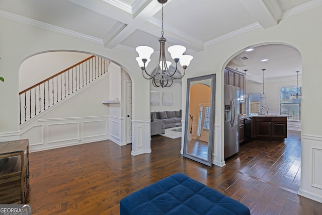 interior space featuring dark wood-style flooring, a decorative wall, ornamental molding, coffered ceiling, and beamed ceiling