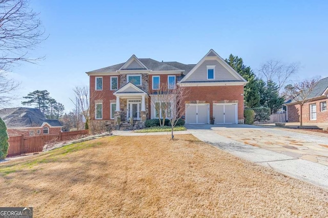 view of front facade featuring concrete driveway, a garage, fence, and a front yard