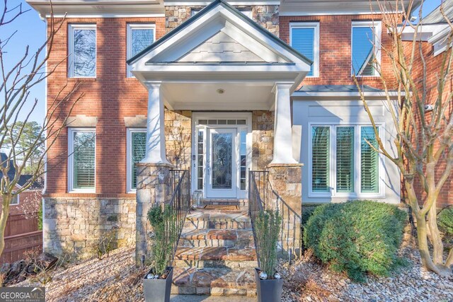 doorway to property featuring brick siding and stone siding