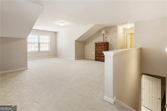 bonus room with light carpet, vaulted ceiling, visible vents, and baseboards