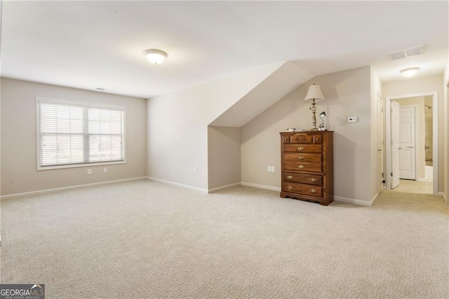 bonus room with light colored carpet, visible vents, and baseboards