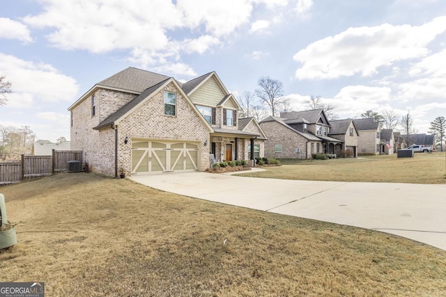 view of front of property with brick siding, concrete driveway, fence, a residential view, and a front lawn