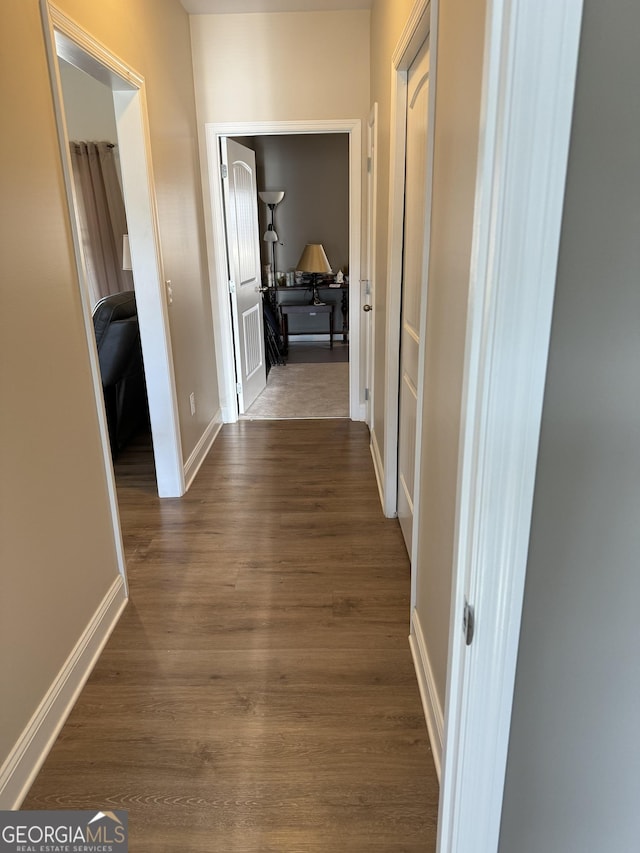 hallway with baseboards and dark wood finished floors