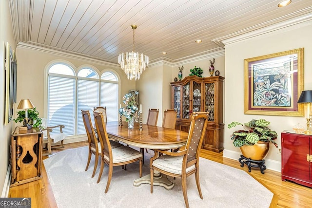 dining room with light wood-style floors, wood ceiling, crown molding, and an inviting chandelier