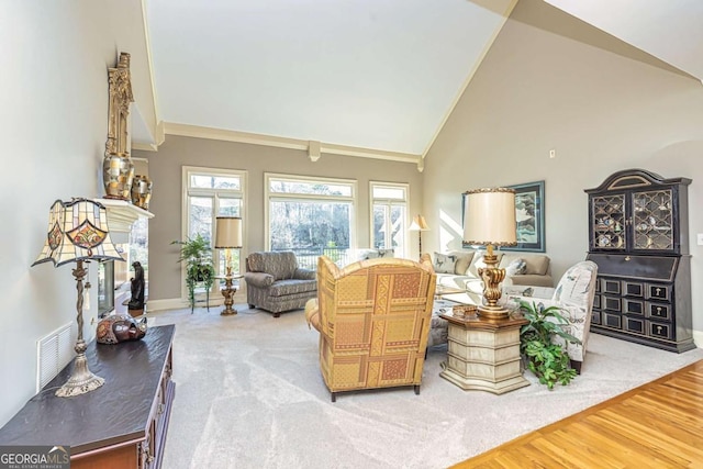 living area featuring high vaulted ceiling, a fireplace, baseboards, light wood-style floors, and ornamental molding