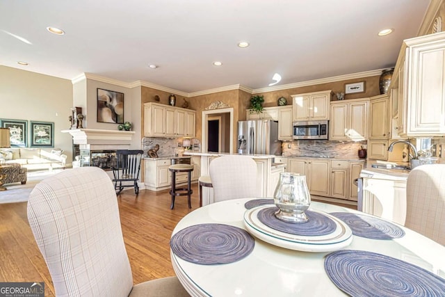 dining area featuring recessed lighting, crown molding, and light wood-style flooring