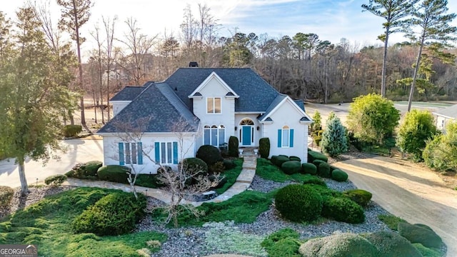 traditional-style house with roof with shingles and stucco siding