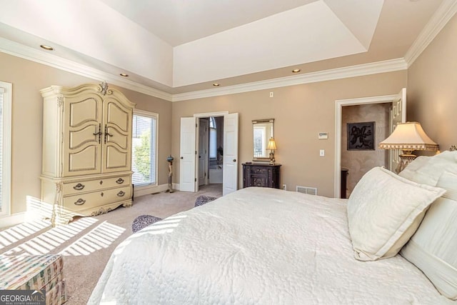 bedroom with light colored carpet, visible vents, baseboards, a tray ceiling, and crown molding