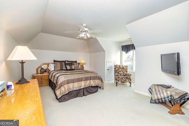 carpeted bedroom with vaulted ceiling, baseboards, and ceiling fan