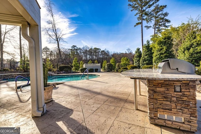 pool with a patio area and area for grilling